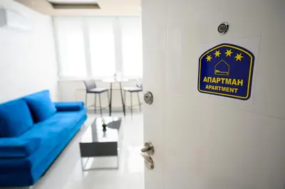 a door with a blue couch in a living room at Apartman Nataly in Niš