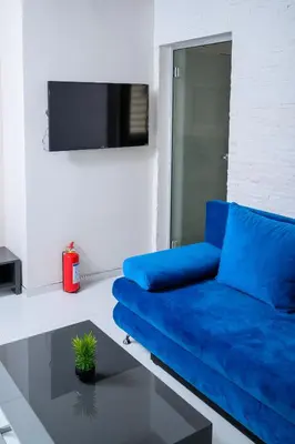 a blue couch in a living room with a tv at Apartman Nataly in Niš