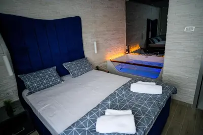 a bedroom with a bed and a bath tub at Spa Apartman Grand in Niš