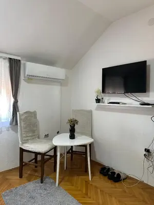 a living room with a table and two chairs and a tv at Hostel Gray in Kruševac
