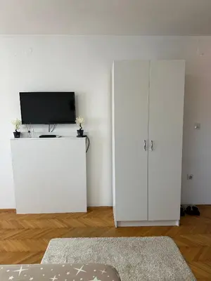 a living room with a tv and a white cabinet at Hostel Gray in Kruševac