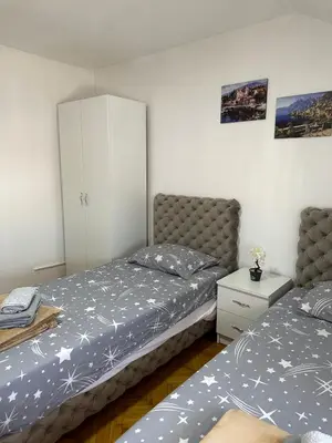 a bedroom with two beds and a white cabinet at Hostel Gray in Kruševac