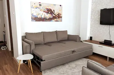 a living room with a couch and a tv at A Comfortable Base for Work & Life in Niš