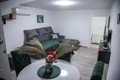 a living room with a couch and a table with flowers at Happy in Pirot