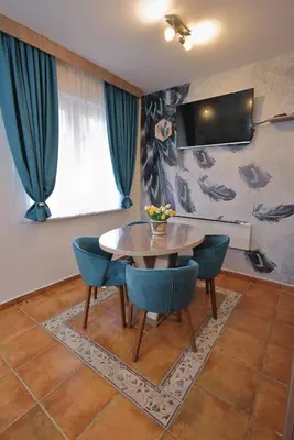 a dining room with a table and blue chairs at GOLD Lux in Vrnjačka Banja