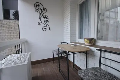 a balcony with a table and chairs and a window at GOLD Lux in Vrnjačka Banja