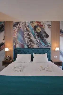 a bed with two pillows on it with a painting at GOLD Lux in Vrnjačka Banja