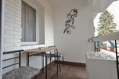 a balcony with a table and two stools at GOLD Lux in Vrnjačka Banja