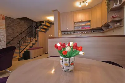 a vase of red and white tulips sitting on a table at GOLD Lux in Vrnjačka Banja