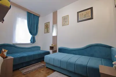a living room with two blue couches and a window at GOLD Lux in Vrnjačka Banja
