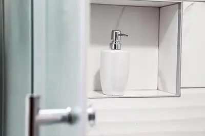 a bathroom with a soap dispenser on a mirror at Apartman Hris in Vrnjačka Banja
