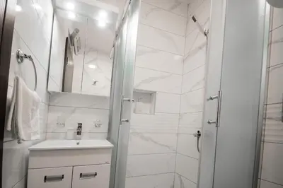 a white bathroom with a shower and a sink at Apartman Hris in Vrnjačka Banja