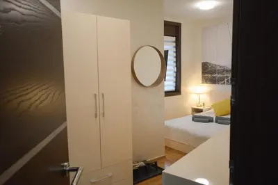 a bedroom with a white cabinet with a mirror at Apartman Hris in Vrnjačka Banja