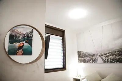 a bedroom with a mirror and a window at Apartman Hris in Vrnjačka Banja