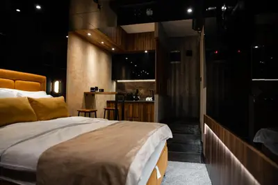 a bedroom with a large bed and a kitchen at MaLux Nis in Niš
