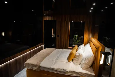a bedroom with a bed with white sheets and yellow pillows at MaLux Nis in Niš