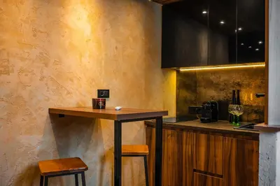 a kitchen with a table and two stools at MaLux Nis in Niš