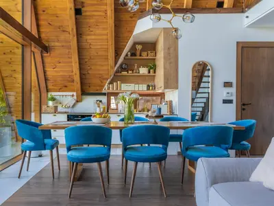 a dining room with a wooden table and blue chairs at Sofia - Mountain Home in Kopaonik