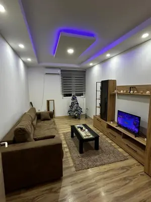 a living room with a couch and a christmas tree at Mance apartments in Paraćin