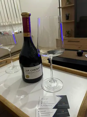 a bottle of wine and two glasses on a table at Mance apartments in Paraćin
