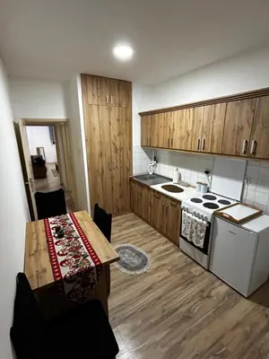 a kitchen with a table and a stove and cabinets at Mance apartments in Paraćin