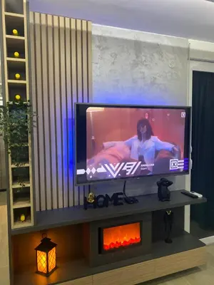 a flat screen tv sitting above a fireplace in a living room at SpaNish apartman in Niš