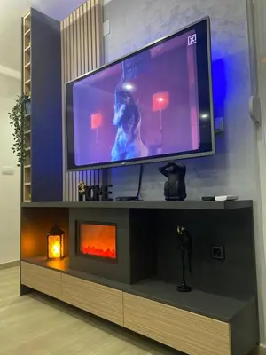 a large television on a entertainment center with a fireplace at SpaNish apartman in Niš