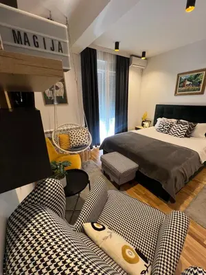 a living room with a bed and a couch at Magija in Vrnjačka Banja