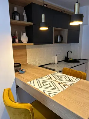 a kitchen with a wooden table with two chairs at Magija in Vrnjačka Banja