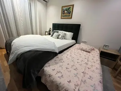 a bedroom with a large bed with a blanket at Magija in Vrnjačka Banja