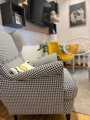 a living room with a chair and a tv at Magija in Vrnjačka Banja