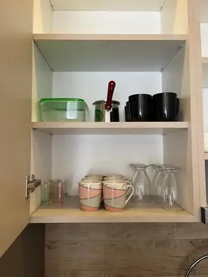 a shelf with bowls and other kitchen utensils at Sunrise Apartman Kopaonik in Cajetina