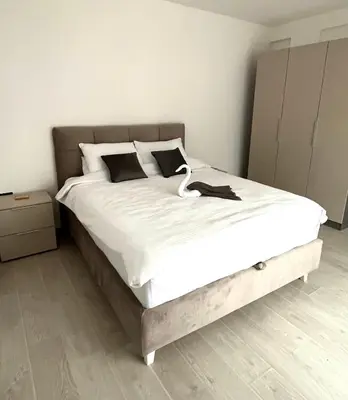 a bedroom with a large bed with white sheets at Sunrise Apartman Kopaonik in Cajetina