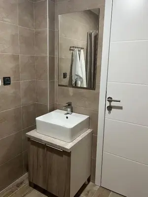 a bathroom with a white sink and a mirror at Sunrise Apartman Kopaonik in Cajetina