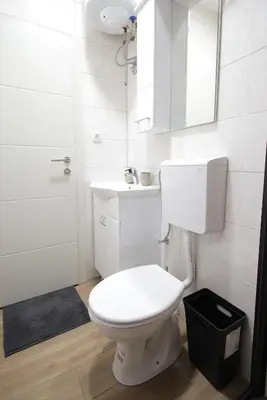 a white bathroom with a toilet and a sink at Soho in Vrnjačka Banja