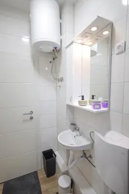 a white bathroom with a sink and a mirror at Soho in Vrnjačka Banja