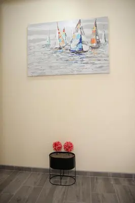 a painting of sailboats in the water on a wall at Soho in Vrnjačka Banja