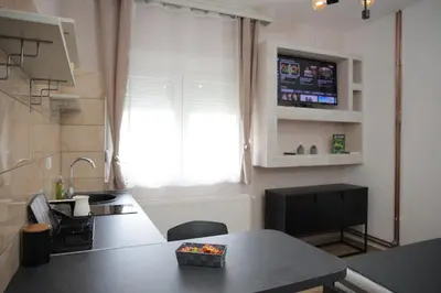 a kitchen with a table and a sink and a window at Soho in Vrnjačka Banja
