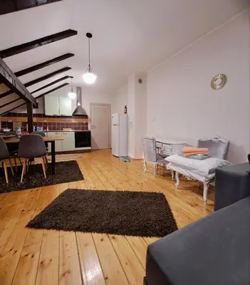 a living room with a table and chairs and a kitchen at Sofi in Niš