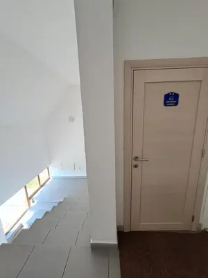 a white door with a blue sign on it in a room at Sofi in Niš
