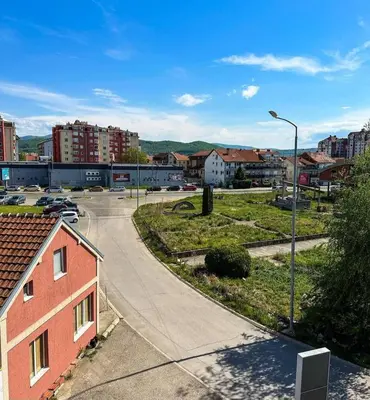 an empty street in a city with buildings and a street light at Sofi in Niš