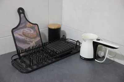 a black drying rack on a counter with a coffee maker at Soho 1 in Vrnjačka Banja