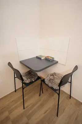 a table with two chairs and a table with a plate of food at Soho 1 in Vrnjačka Banja