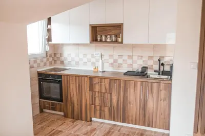 a kitchen with wooden cabinets and a sink at Sunny Paradise in Vrnjačka Banja