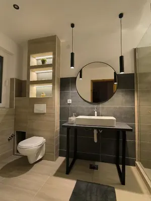 a bathroom with a sink and a toilet and a mirror at Smestaj Dzentlmen in Soko Banja