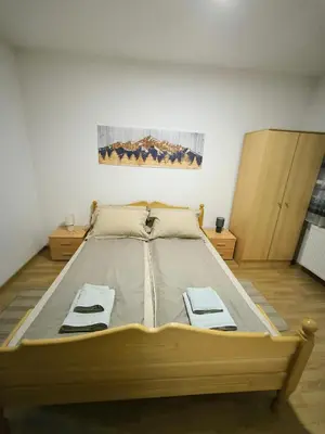 a large bed in a room with two cabinets at Smestaj Dzentlmen in Soko Banja