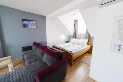 a living room with a couch and a bed at Smestaj Dzentlmen in Soko Banja