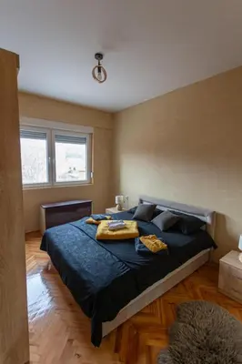 a bedroom with a large bed with blue sheets and pillows at Fenix1 in Knjazevac.
