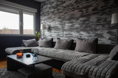 a living room with two couches and a stone wall at Fenix1 in Knjazevac.