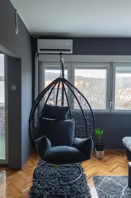 a swing chair in a room with two windows at Fenix1 in Knjazevac.